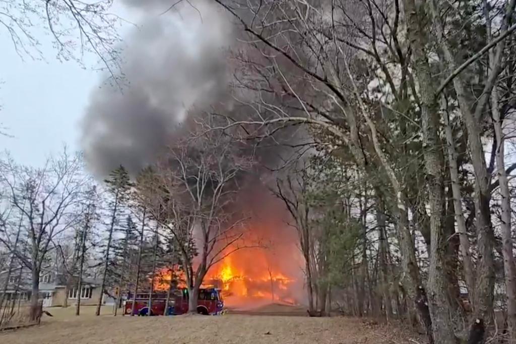 Authorities and local residents observing a large fire caused by an airplane crash into a house in Brooklyn Park, Minnesota